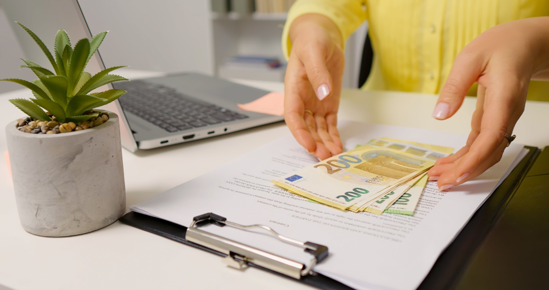 Opening a clipboard female hands counting bill for payday.