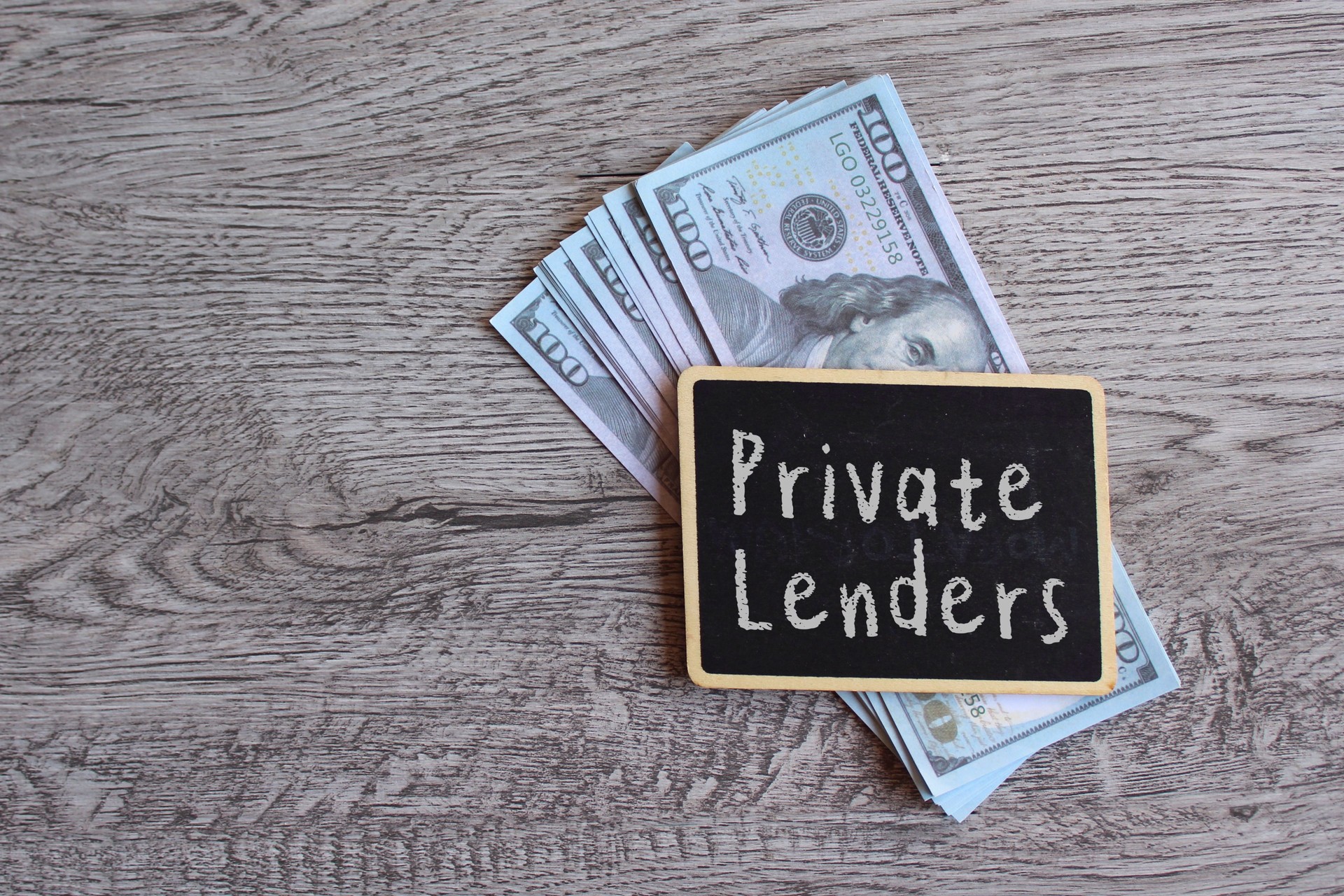 Top view image of money and chalkboard with text PRIVATE LENDERS